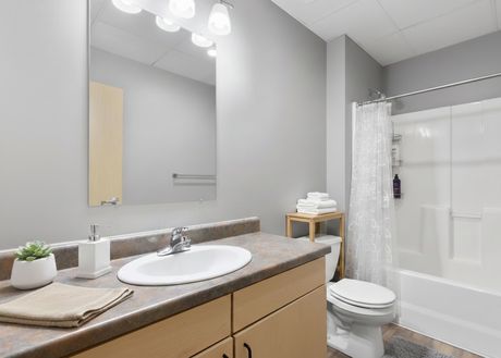 A bathroom with a tub/shower combo and vanity