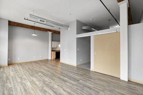 A living space with an exposed wood beam and sliding bedroom door